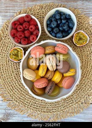 Macarons and berries raspberries, blueberries on wooden background ...