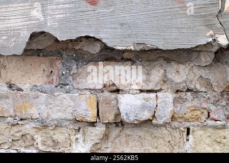 The texture of a very old vintage brick wall with residual elements of plaster concrete decoration Stock Photo