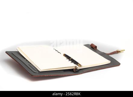 Opened notebook with a pen on a page on a white background. Stock Photo