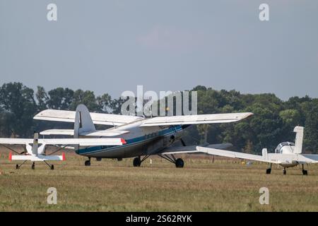 Antonov An-2 single-engine biplane passenger aircraft with other light planes on airshow landing field Stock Photo