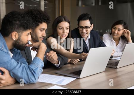 Group of professionals working together on joint task using laptops Stock Photo