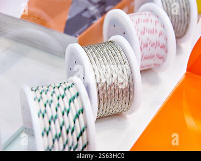 Metal and fabric braided cables on spools in store Stock Photo