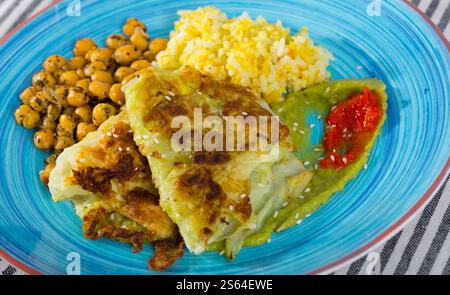 Cabbage in batter with spicy rice, chickpeas and sauces Stock Photo