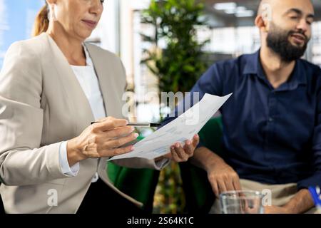 Staff member in modern diverse startup office showing manager progress on customer commissioned project. Accountant presenting team leader key data statistics after business audit Stock Photo