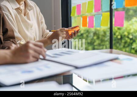 Business People working on sticky notes creative writing down ideas on post it notes professional investor start up project business Stock Photo