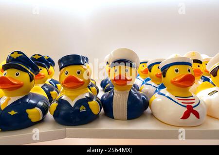 Various yellow rubber toy ducks on a shelf in a store selling as a gift Stock Photo