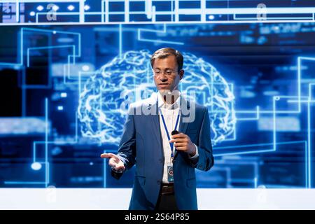 Programmer presenting how AI technologies can bring companies increased productivity during IT congress. Professional talks about implementation of AI driven solutions during tech summit Stock Photo