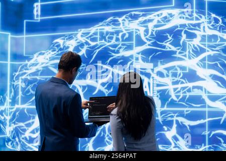 Engineers using devices and AI neural networks modeled after human brain to solve complex problems. Workers using artificial intelligence deep learning to look at data and complete tasks Stock Photo