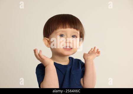 Portrait of cute little boy on light grey background Stock Photo