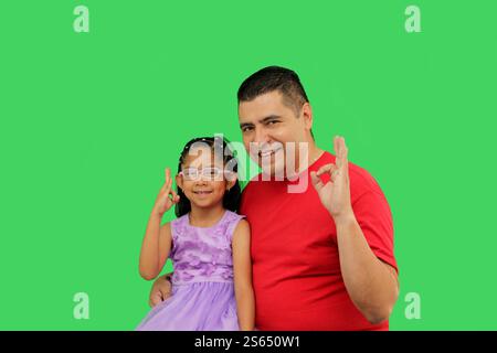 Divorced single dad with his brunette Latin daughter dressed in a princess  dress in front of the green screen bumping fists Stock Photo - Alamy
