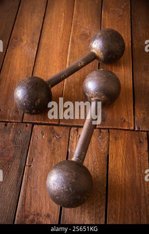 Old rusty dumbbells on rustic wood board background texture. Old rusty dumbbells on wood background texture Stock Photo