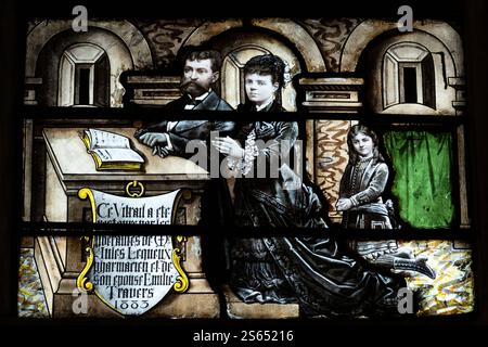 Stained-glass window commemorating pharmacist and mayor Jules Lequeux alongside his wife Emilie, located in Pont de l'Arche, Normandy. Stock Photo