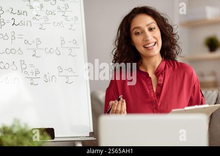 Lady teacher explaining trigonometric functions to students online using pc Stock Photo