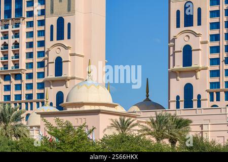 Abu Dhabi, UAE - January 3, 2025: The striking dome of a traditional mosque contrasts with modern high-rise buildings, reflecting Abu Dhabi's unique a Stock Photo