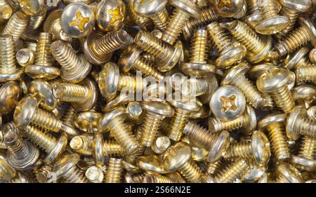Phillips ovalhead gold screws scattered loosely work tools hardware accessories. Stock Photo