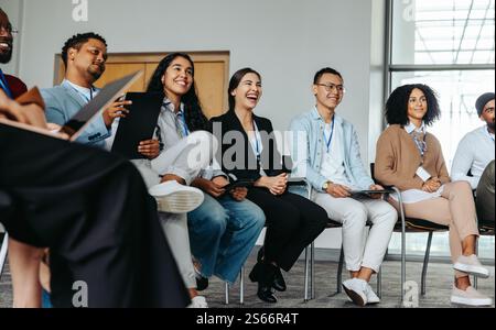 Joyful team in an office setting enjoying a casual networking session, smiling and sharing ideas together. Stock Photo