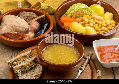 Soup and trays with the ingredients of a typical Madrid stew Stock Photo