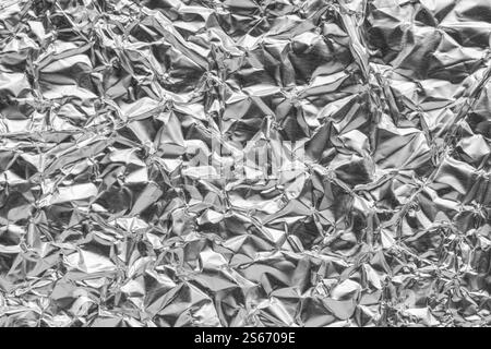 Crumpled bright shiny metallic silver aluminium foil background, flat lay view backdrop with copy space for text Stock Photo