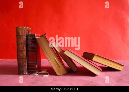 Row of red books on red grungy background, reading, learning, education or home office concept Stock Photo