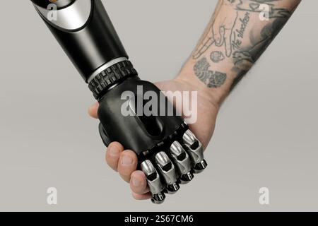 a robot and human holding hands Stock Photo