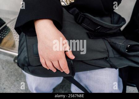 girl's hand lies on backpack. protection from theft of things in a backpack Stock Photo