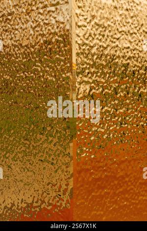 stamped gold-colored iron sheet. textured tin sheet on the wall Stock Photo
