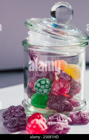 Close-up of a glass jar filled with colorful textured candies, highlighted by natural sunlight Stock Photo