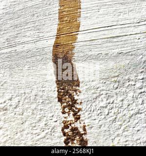 A close-up of a textured white concrete surface with an abstract earth-toned brushstroke. Ideal for artistic designs. Stock Photo