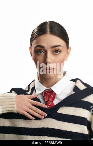 Young woman with striking features showcases a contemplative expression, dressed in casual elegance. Stock Photo