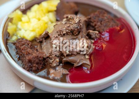 delicious melted chocolate desert served with chopped pineapple and raspberry sauce Stock Photo