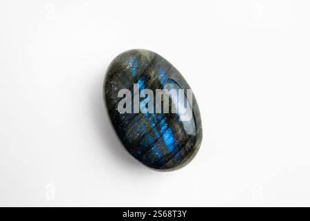 Oval shape blue and black color Labradorite gemstone on white background. Lot of copy space. Stock Photo
