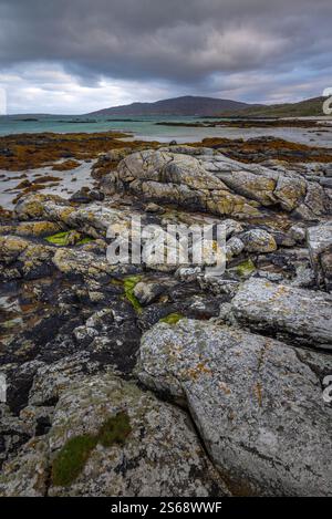 Patterned rocks on Eriskay beach on the Eriskay Coast, Outer Hebrides, on a cloudy and overcast day. Stock Photo