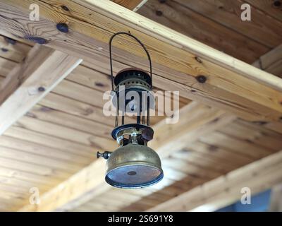 Vintage traditional antique incandescent oil lamp on a wooden ceiling Stock Photo