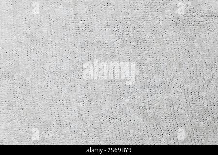 Close-up of a soft, textured, white fabric featuring a looped pattern. The material has a cozy and plush appearance. Stock Photo