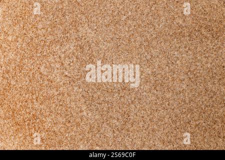 Close-up of coarse tan fabric with visible fibers, rough texture. Backgrounds. Stock Photo
