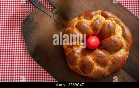 Easter bread, greek tsoureki braid and red easter eggs on table, top view Stock Photo