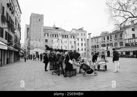 VENICE, ITALY - FEBRUARY 14, 2015: Locals and tourists buying flowers at street market  on Campo Santa Margherita square (Dorsoduro area). Stock Photo