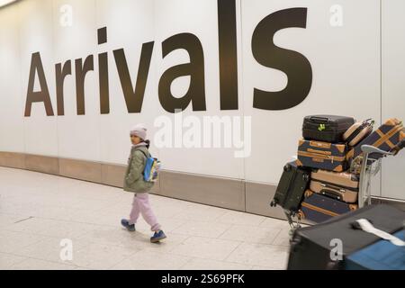 Air travellers arriving at Heathrow Arrivals Hall England UK Stock Photo