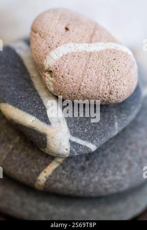 Stacked beach pebbles with white veins, macro closeup. Stock Photo