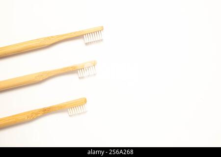 Three wooden toothbrushes on a white background, top view. Zero waste concept. Stock Photo