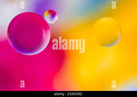 Oil drops in water and air bubbles, macro photo, selective focus. Bright multicolored background. Copy space. Stock Photo