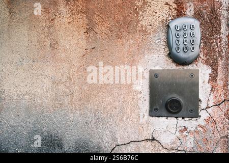 Metal numeric entryway keypad on textured wall Stock Photo