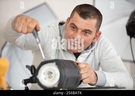 photographer soldering wireless flash trigger at his workplace Stock Photo