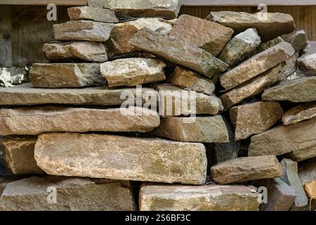 Old stone wall bricks piled up in garden in Bristol Stock Photo