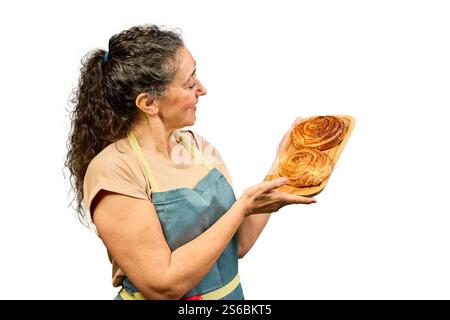 Woman in an apron holds a wooden board with two croissants on it Stock Photo