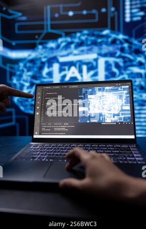 Data scientist in high tech lab analyzing complex AI brain models on laptop. Engineer at work using machine learning on notebook to develop artificial intelligence technology Stock Photo