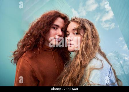 Young couple with long hair posing together outdoors Stock Photo