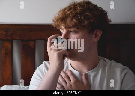 Young man using inhailer for asthma attack Stock Photo