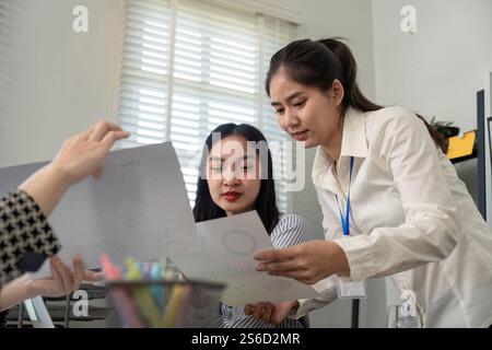 Business team analyzing data reports and collaborating in a modern office Stock Photo
