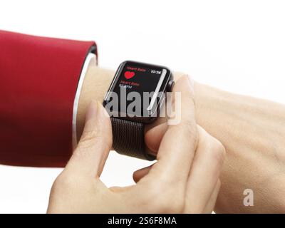 Woman hand with Apple Watch smartwatch on her wrist measuring her heart rate isolated on white background Stock Photo